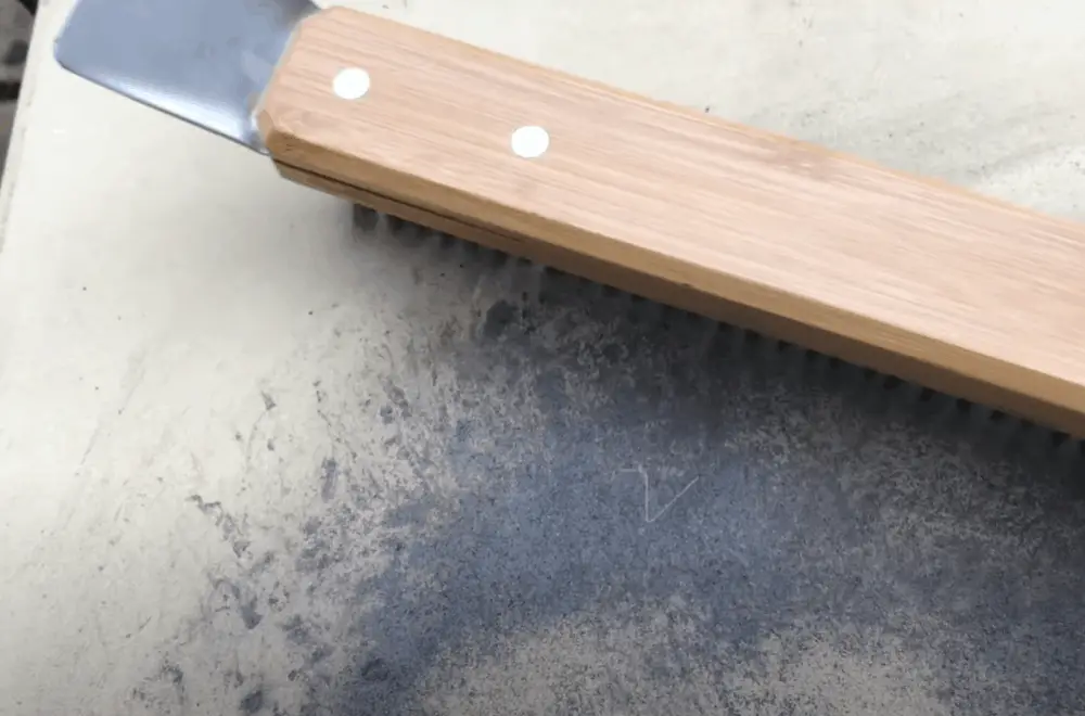 Scrape off the surface of the pizza stone