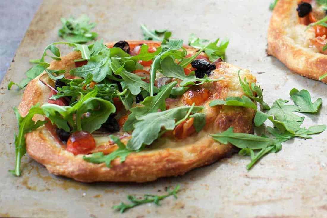 Prosciutto Pizza with Tomatoes, Olives, and Arugula
